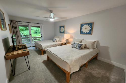 uma sala de estar com duas camas e uma mesa em Heart & Soul Hideaway em Harbor Springs