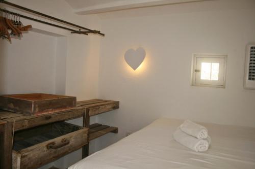 een slaapkamer met een bed en een hart aan de muur bij Can Joseph I in Sant Francesc Xavier