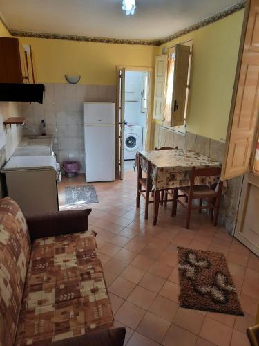 a kitchen and dining room with a table and refrigerator at Casa sotto l'Etna in Giarre