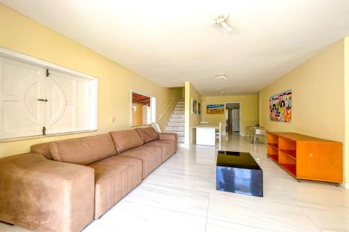 a large living room with a couch and a table at Casa com piscina em Itacimirim BA in Itacimirim