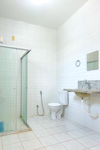 a bathroom with a shower and a toilet and a sink at Casa com piscina em Itacimirim BA in Itacimirim