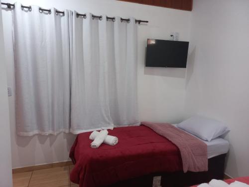 a bedroom with a bed with a teddy bear on it at Suites Estrela in São Pedro da Serra