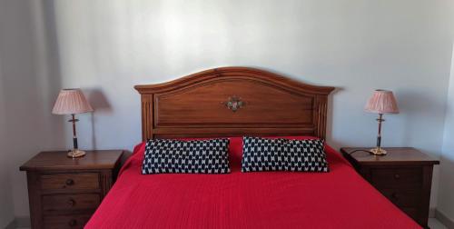 ein Schlafzimmer mit einem roten Bett mit zwei Lampen an Tischen in der Unterkunft Happy Nogalera Centro - Vistas al Mar in Torremolinos