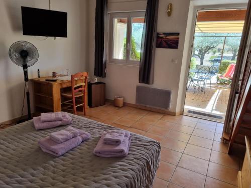 Un dormitorio con una cama con toallas moradas. en La Fanette en Montbrison-sur-Lez