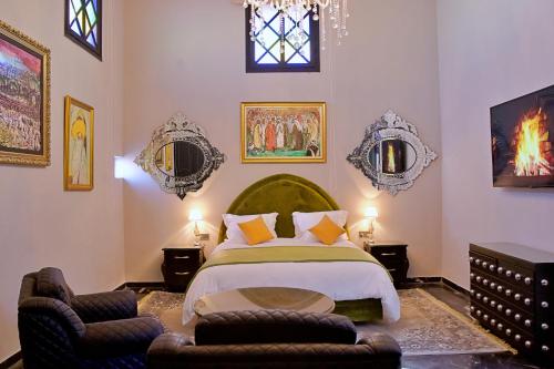 a bedroom with a large bed and two chairs at Dar Chrifa in Rabat