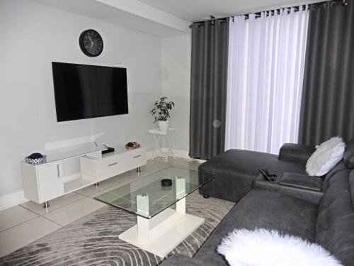 a living room with a couch and a tv at Home away from Home in Windhoek