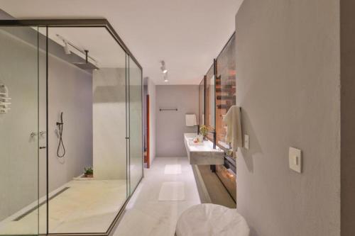 a bathroom with a glass shower and a sink at Villas Taturé in São Miguel dos Milagres