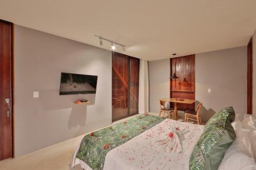 a bedroom with a large bed and a table at Villas Taturé in São Miguel dos Milagres