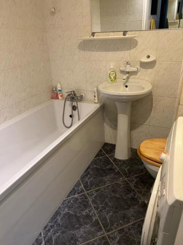 uma casa de banho com um lavatório, uma banheira e um WC. em Apartament Baltic Sea em Gdańsk