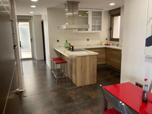 a kitchen with a sink and a counter with stools at Luxurious villa in Altea Hills in Altea