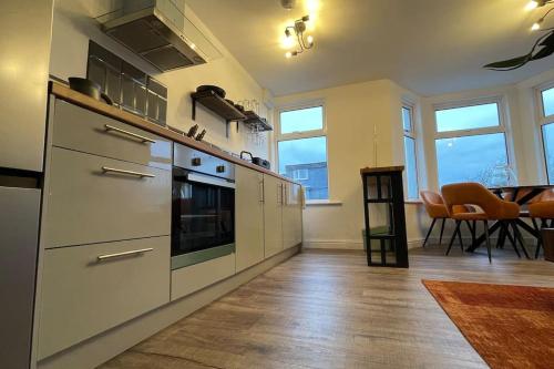 uma cozinha com electrodomésticos de aço inoxidável e uma sala de jantar em The Lounge em Newquay