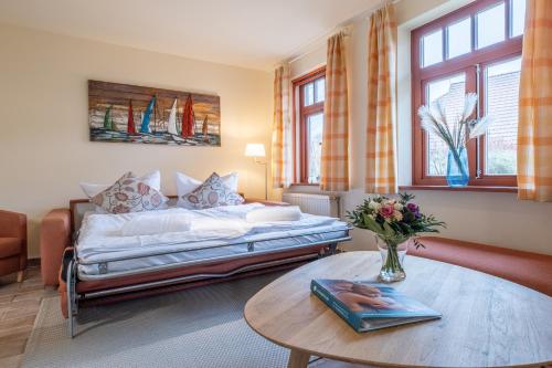 a bedroom with a bed and a coffee table at Ferienhaussiedlung Strandperlen Sanddornhof 4b (Typ IX) in Wustrow