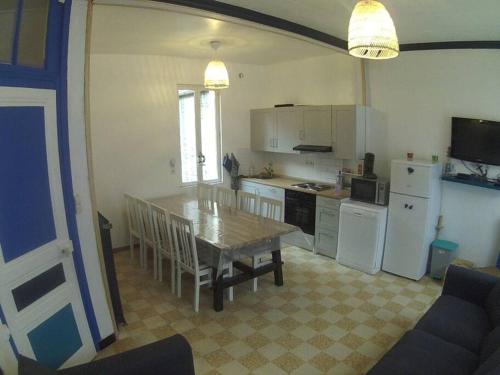une cuisine avec une table et une cuisine avec des appareils électroménagers blancs dans l'établissement 100m plage- 4 Chambres-quartier classé *bleu-mers*, à Mers-les-Bains