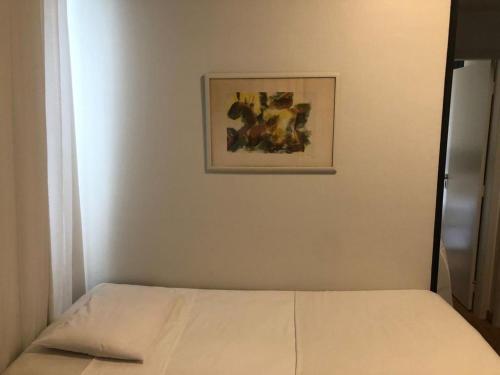 a bed in a room with a picture on the wall at Condomínio Max Savassi Superior apto 1502 in Belo Horizonte