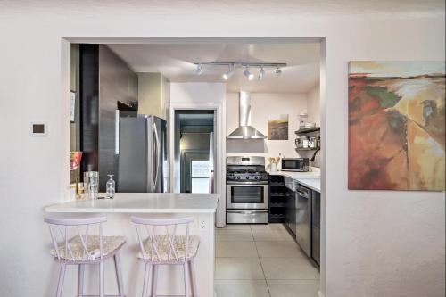 a kitchen with a white counter and two bar stools at The Wesley Walla Walla in Walla Walla