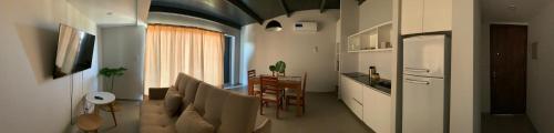a living room with a couch and a table and a kitchen at Bosques de Mayo Departamento 4 in Maipú