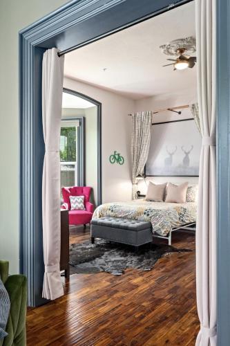 a bedroom with a canopy bed and a red chair at The Wesley Walla Walla in Walla Walla