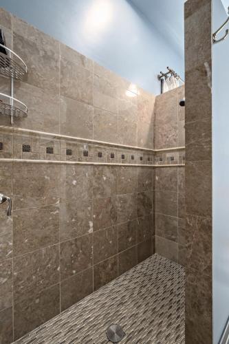 a bathroom with a large shower with brown tiles at The Wesley Walla Walla in Walla Walla