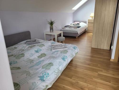 a bedroom with two beds and a wooden floor at Dom Wakacyjny Jastrzębia Góra in Jastrzębia Góra