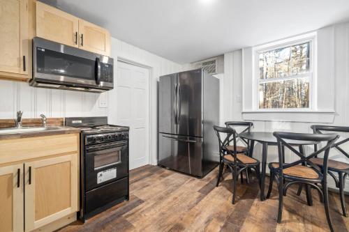 a kitchen with a black refrigerator and a table with chairs at The Inn & More in Bartlett