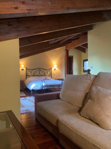 a living room with a couch and a bed at Ático Dúplex en Laspaúles in Laspaúles
