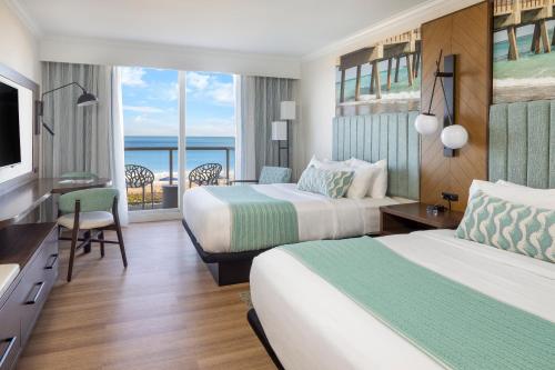 a hotel room with two beds and a view of the ocean at The Lucie in Jensen Beach