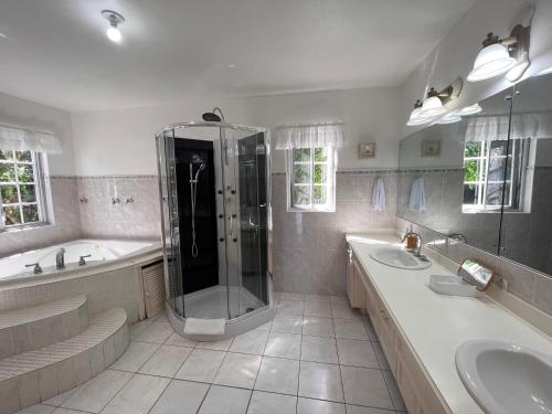 a large bathroom with two sinks and a shower at All Nations Guest House in Port Antonio