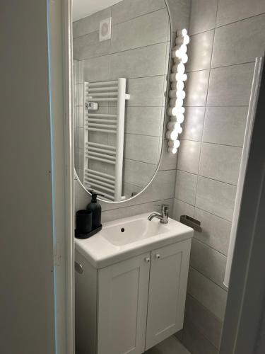 a bathroom with a sink and a mirror at La Petite Maison in Pont-d'Ouilly