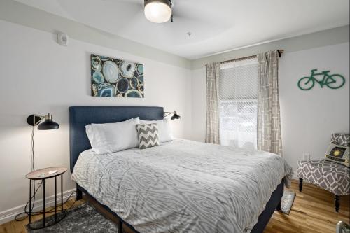 a bedroom with a bed with a blue headboard and a window at The Wesley Walla Walla in Walla Walla