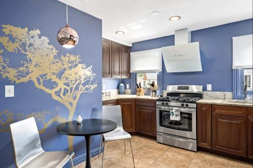 a kitchen with blue walls and a tree mural on the wall at The Wesley Walla Walla in Walla Walla