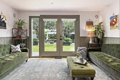 a living room with green couches and a door at The Wesley Walla Walla in Walla Walla