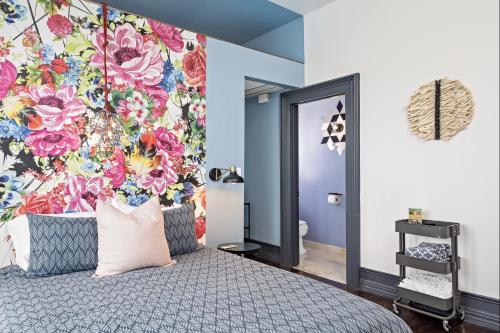 a bedroom with a floral mural on the wall at The Wesley Walla Walla in Walla Walla