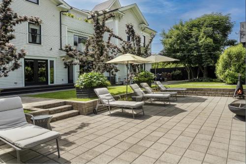 a patio with chairs and umbrellas in front of a house at The Wesley Walla Walla in Walla Walla