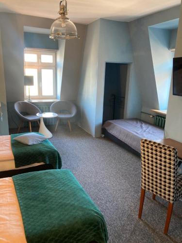 um quarto com 2 camas, uma mesa e cadeiras em Apartamenty PRZY FONTANNIE em Zielona Góra