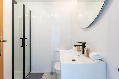 ein weißes Badezimmer mit einem Waschbecken und einem Spiegel in der Unterkunft Beachside Retreat with Private Terrace in Benalmádena