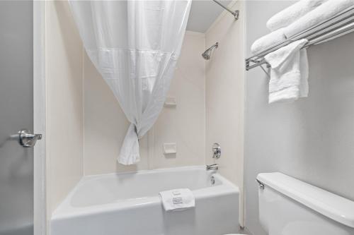 a white bathroom with a shower and a toilet at Red Lion Inn & Suites Deschutes River - Bend in Bend