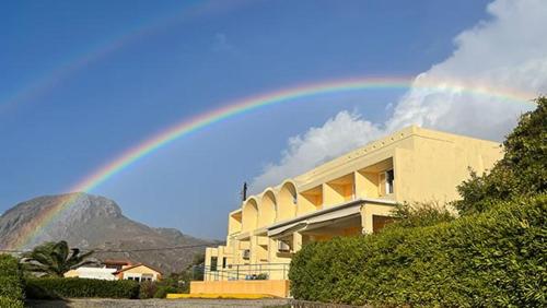 a rainbow in the sky over a building at Phoenix-Hotel in Plakias
