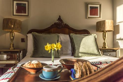 uma cama com uma bandeja de pão e flores em Top Joe's Townhouse em Narberth