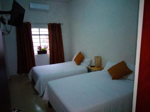 a hotel room with two beds and a window at LOS ARCOS in Agua Buena