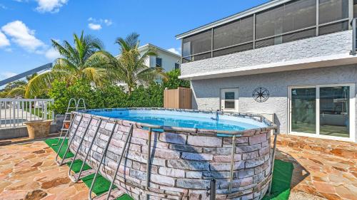 a swimming pool in front of a house at Tavernier Keys Home w/70’ Dock & 20k Boat Lift on Bayside! 3/2.5 Plus Game Room in Tavernier