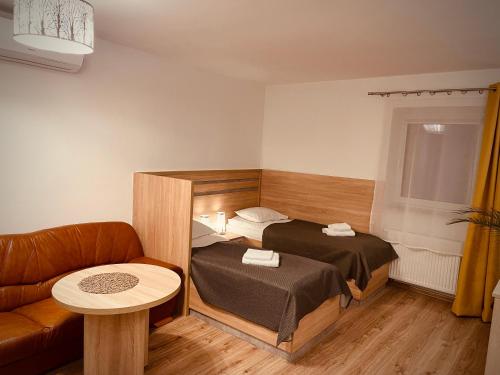 a small room with a bed and a couch at Apartamenty Grodowa 2 in Gliwice