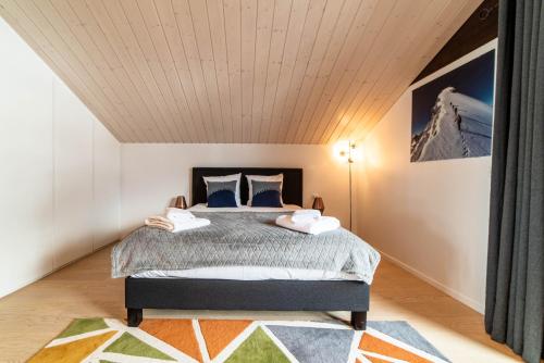 um quarto com uma cama e um tecto em madeira em Chalet Genepi - spectacular ski and summer home em Saint-Gervais-les-Bains