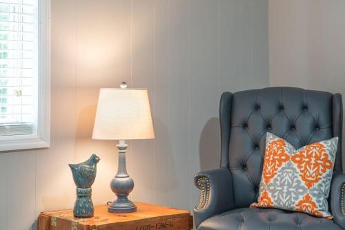 a blue chair sitting next to a table with a lamp at Cozy basement apartment in Fayetteville