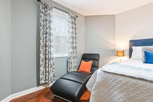 a bedroom with a bed and a chair next to a window at Cozy basement apartment in Fayetteville