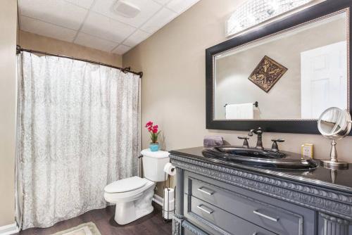 uma casa de banho com um lavatório, um WC e um espelho. em Cozy basement apartment em Fayetteville