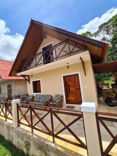 ein Haus mit einer großen Terrasse davor in der Unterkunft Chalé Kalmaria in Guaramiranga