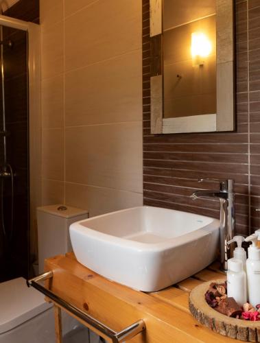 a white bath tub sitting on a wooden counter in a bathroom at Casas de Campo do Castro da Cola in Marchicão