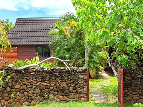 a stone fence in front of a house at MOOREA - Bungalow Moekea Lagoon in Hauru
