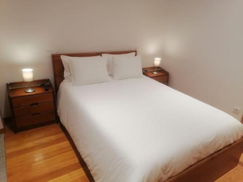 a bedroom with a large white bed with two night stands at Garrett Houses in Póvoa de Varzim