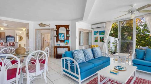 a living room with a blue couch and chairs at Turtle's Nest Beach Resort in Meads Bay